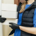 close-up-delivery-woman-holding-boxes